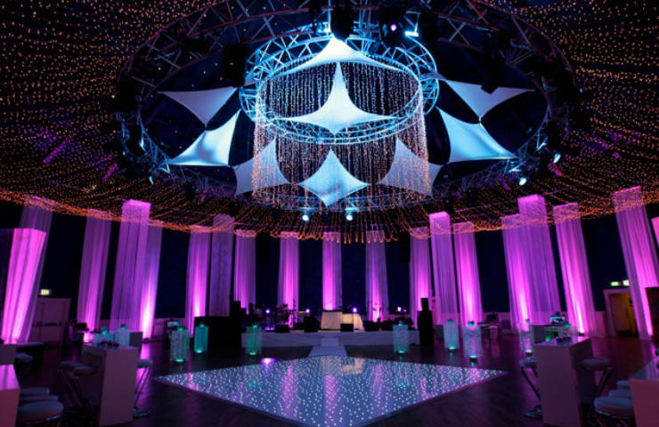 party decor with fairy light ceiling, sparkly white dance floor and square fringe tubes hanging lit in pink
