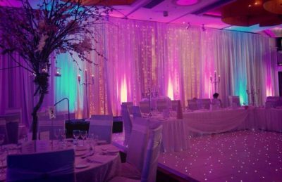 Wedding hotel interiors design with lit up backdrop and wedding top table