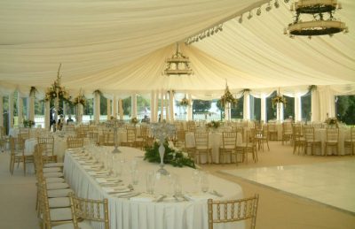 wedding marquees interior design with golden chiavary chairs, glass candelabras and white drapery